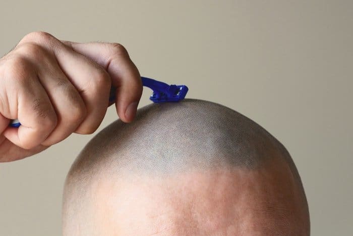 Man Shaving head - choosing razor